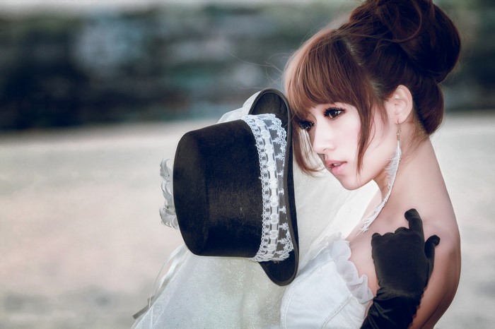 Elegant Woman in White Dress with Black Hat