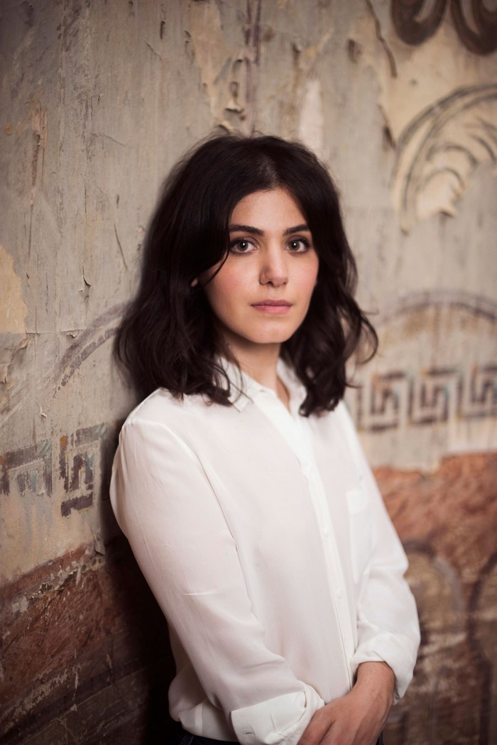 Katie Melua leaning against a textured wall