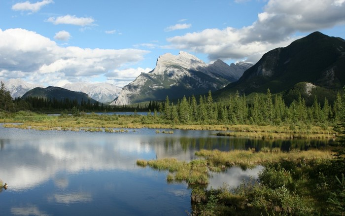Lake and mountains with reflections under a cloudy sky