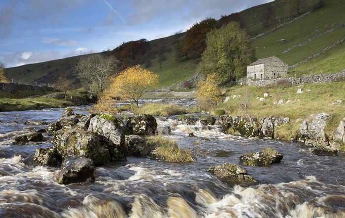 River flowing through a rocky landscape with a stone building