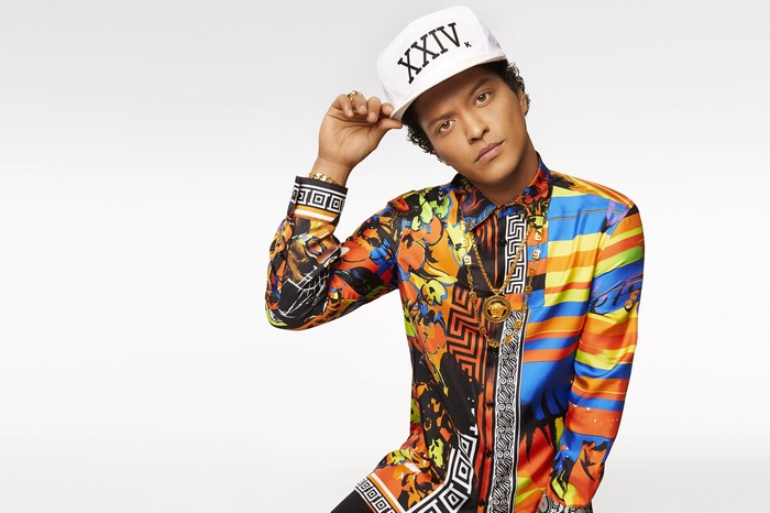 Bruno Mars wearing a colorful shirt and a white cap