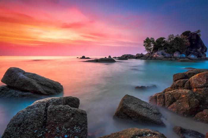 Rocky shore at sunset with colorful sky and calm sea