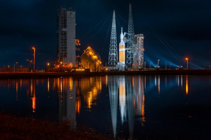 Rocket on launchpad at night with water reflection