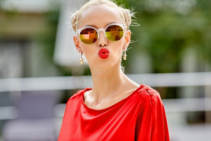 Woman with blonde hair wearing sunglasses and red dress