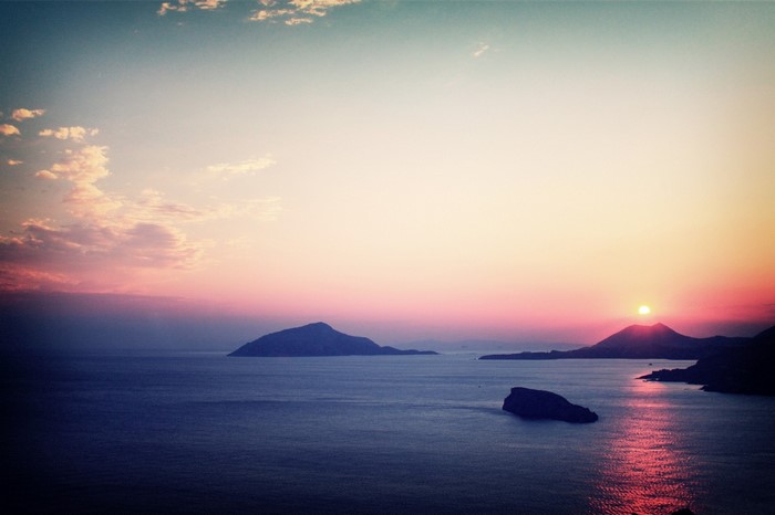 Sunset over the sea with islands and reflection