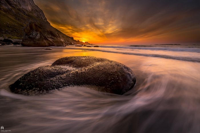 Sunset over a rocky beach with waves