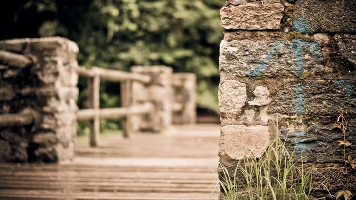 Stone wall with graffiti and wooden walkway