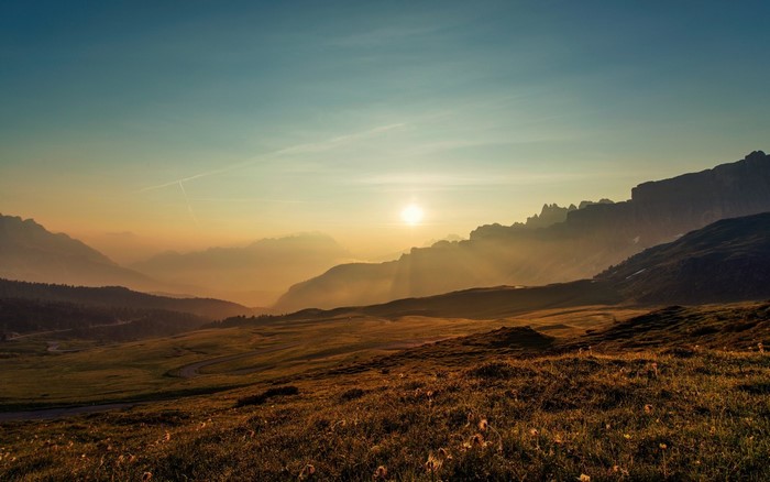 Sunrise over a misty mountain valley with rolling hills