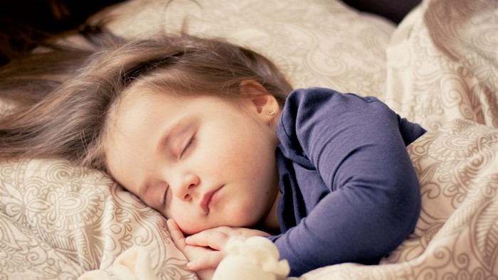A young girl sleeping peacefully in bed