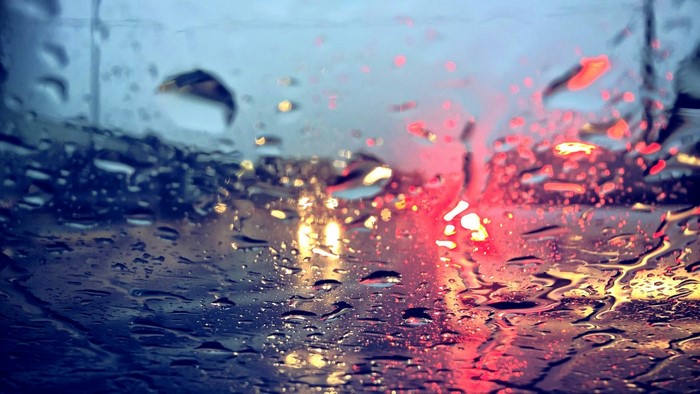 Raindrops on a car windshield with traffic lights