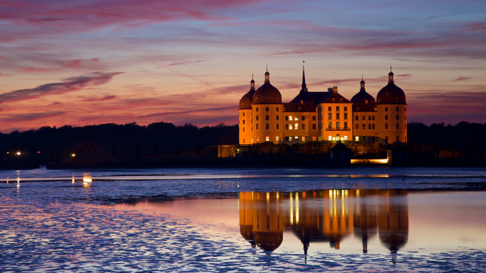 Moritzburg Castle reflected in water at sunset