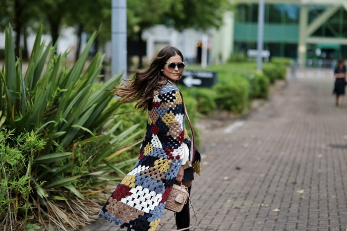Woman wearing a colorful crochet cardigan and sunglasses