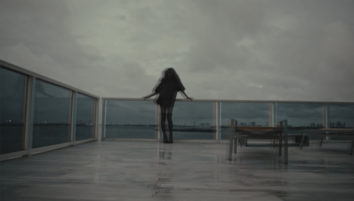 Woman on a balcony overlooking a city skyline