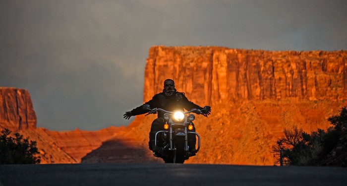 Biker riding a motorcycle at sunset in the desert