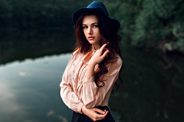 Woman wearing a hat and shirt by the water