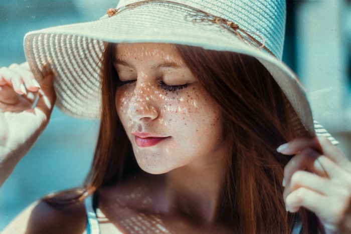 Woman with freckles wearing a straw hat