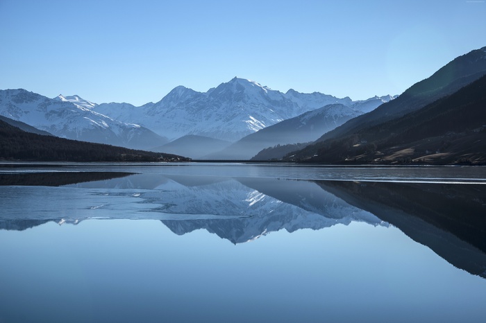 Snow-capped mountains reflected in a calm lake