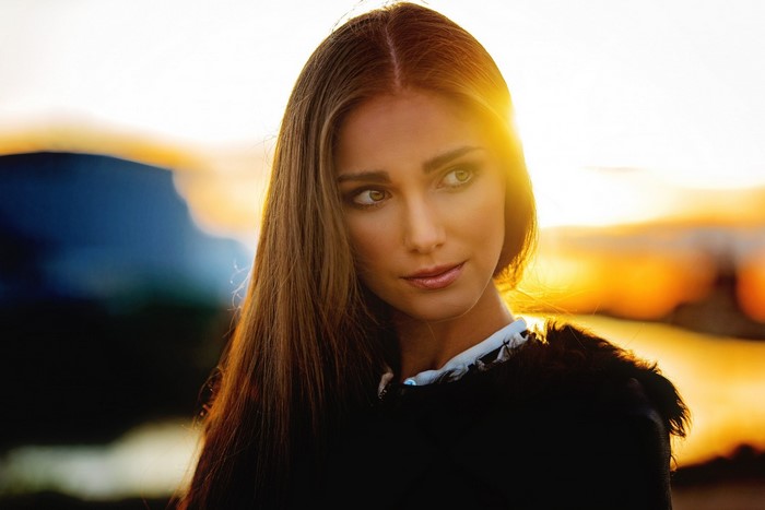 Woman with long auburn hair at sunset