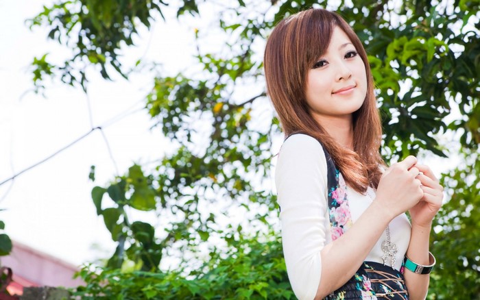 Young woman with long brown hair posing outdoors