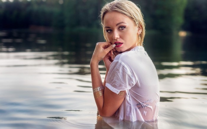 Woman in wet white shirt in water