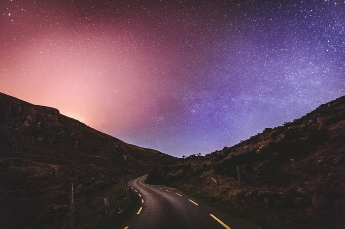 Winding road under a starry night sky