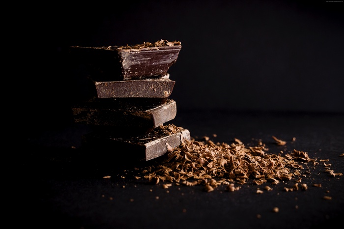 Stack of dark chocolate pieces with shavings