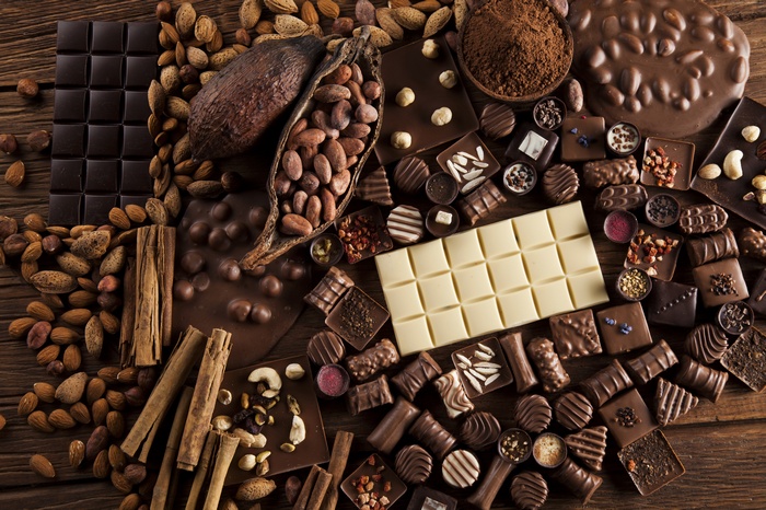 Assortment of chocolates, cocoa beans, almonds, and cinnamon sticks