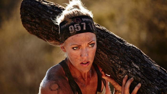 Woman carrying a tree trunk during a Spartan Race