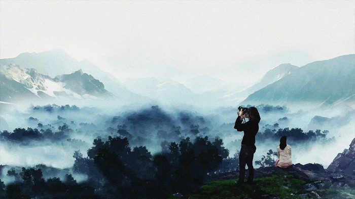 Photographer and woman in misty mountains