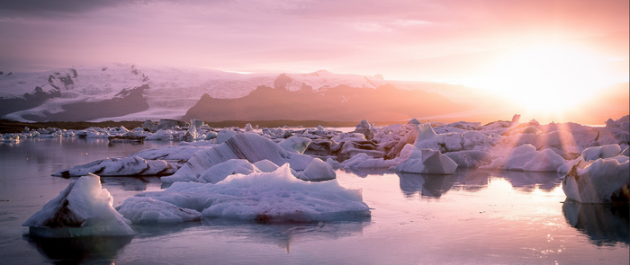 Icebergs floating in water at sunset