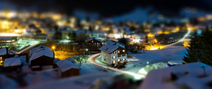 Tilt-shift photography of a snowy village at night