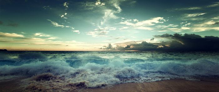 Waves crashing on a beach at sunset