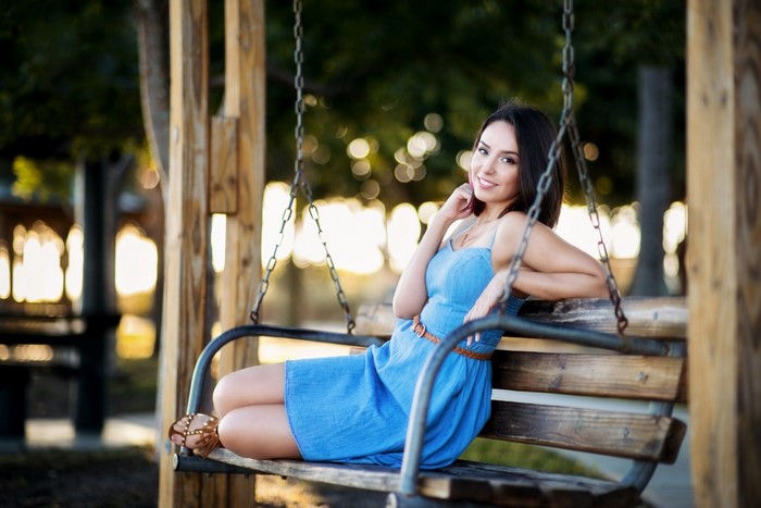 Woman in blue dress sitting on a swing