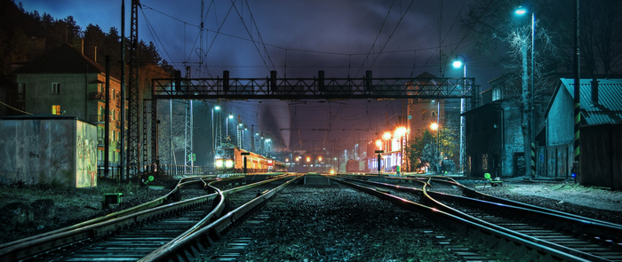 Train station at night with electric trains and tracks