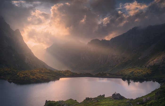 Mountain lake with sun rays through clouds