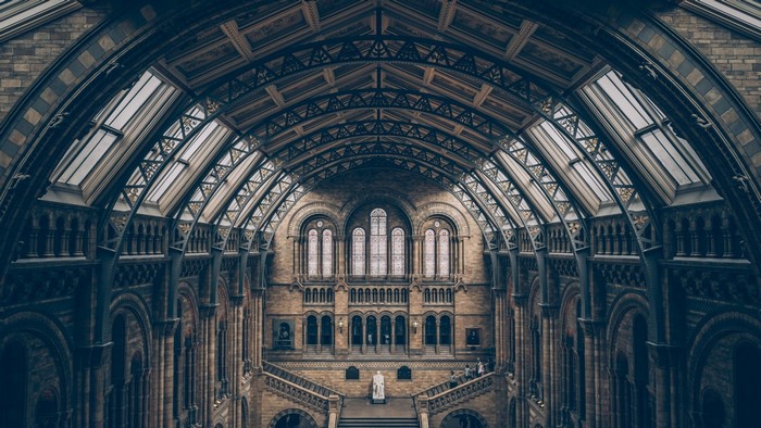 Interior of a grand stone building with arched windows and a vaulted ceiling