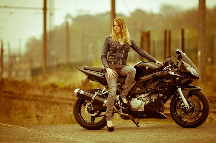 Woman sitting on a black Suzuki SV 650 motorcycle