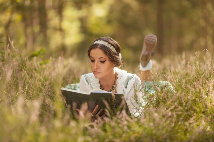 Woman reading a book in a meadow