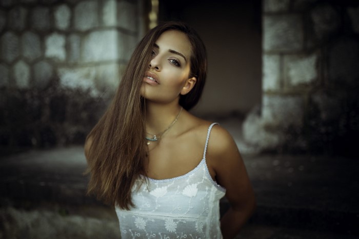 Woman with long brown hair wearing a white dress