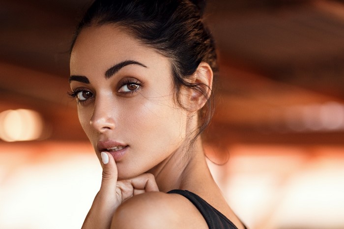 Close-up portrait of a woman with finger on lips