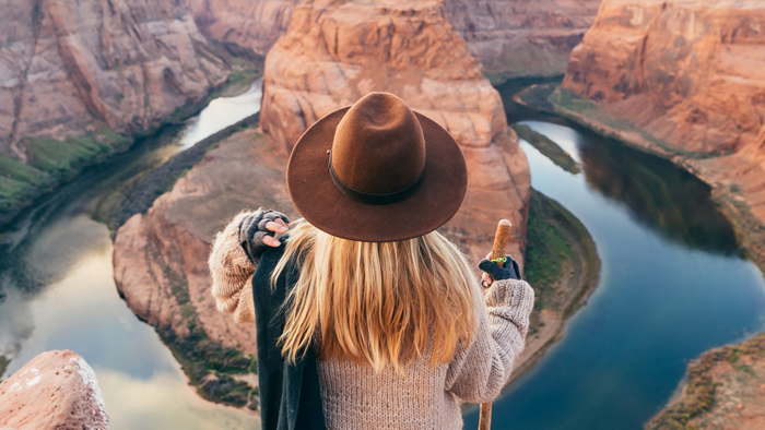 Woman in hat overlooking Horseshoe Bend canyon