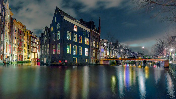 Amsterdam canal at night with reflections
