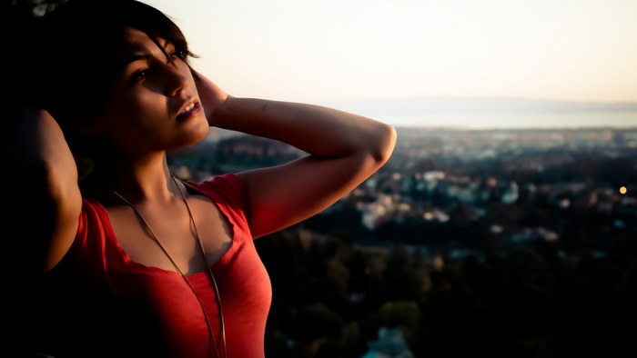Woman in red shirt looking away at sunset