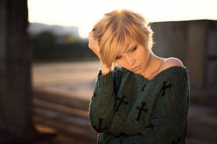 Woman with blonde hair wearing a green sweater
