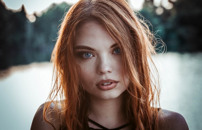 Portrait of a young woman with red hair and blue eyes
