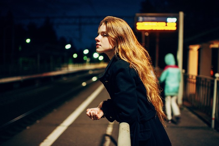 Redhead woman at train station at night