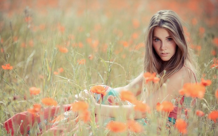Woman with Blue Eyes in a Sunny Poppy Field