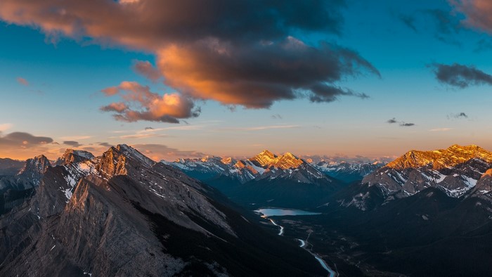 Mountain range at sunset with clouds and lake