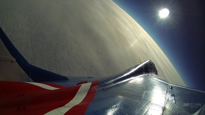 MiG-29 aircraft wing in space with sun and clouds