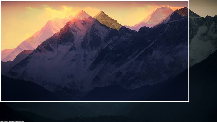 Snowy mountains at sunrise with golden light